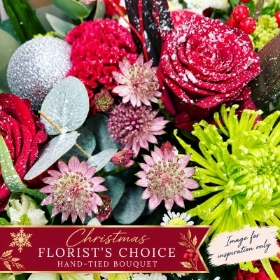 Christmas Florist's Choice Hand-Tied Bouquet by PICKaPOSY, featuring a festive close-up of red roses, green chrysanthemums, astrantia, eucalyptus and silver decorations. Example image only.